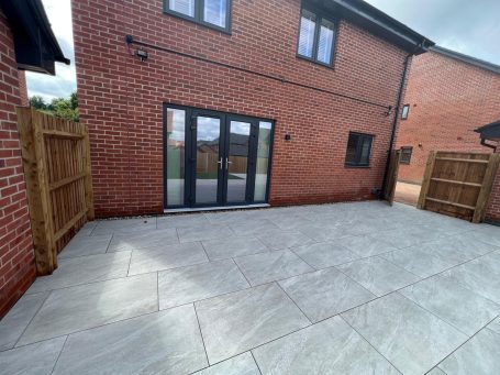 Paved outdoor area with brick walls and glass doors leading to the interior.