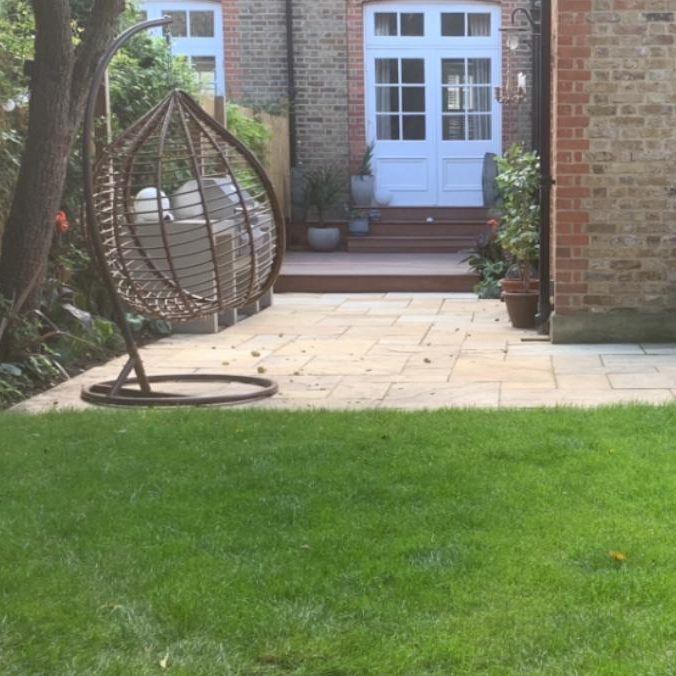 Garden area with a hanging chair and patio doors in the background.